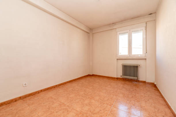 istock empty room with orange stoneware floors, wrought iron radiator and white aluminum window 1483935676
