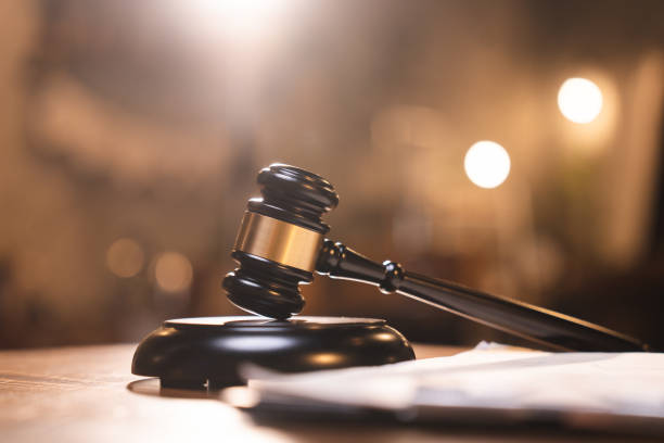 istock Judge gavel on the table with blurry books in the background 1483937584