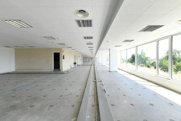 istock Elongated industrial warehouse offices with technical ceilings and floors with unpaved gutters and a wall of windows with views 1483937794