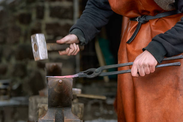 istock The blacksmith hits the hot workpiece on the anvil with a hammer. 1483939118