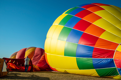 A single hot air balloon floating in the clouds during a balloon festival.