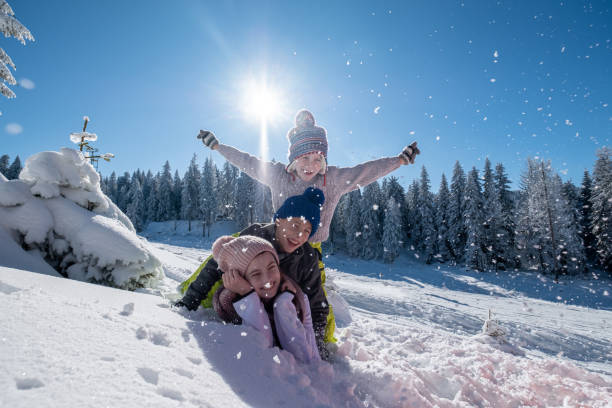 children are lying on top of each other in the snow stock photo