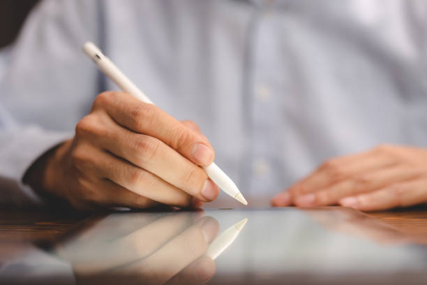 istock business communication technology concept, businessman person using digital pen to working on tablet computer screen device in modern office workplace, online marketing document on desk table 1483946041