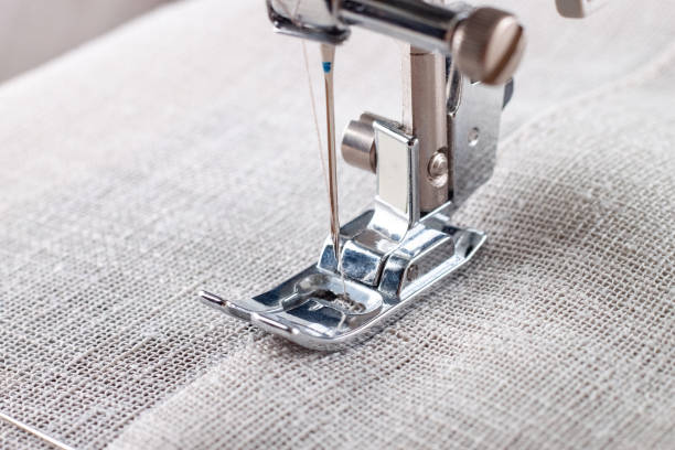 istock Modern sewing machine presser foot with linen fabric and thread, closeup 1483948287