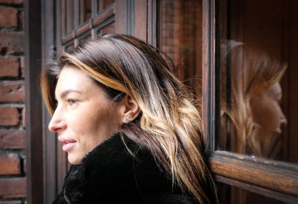 istock A young woman standing at a window 1483952628