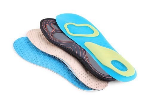 Four different shoe insoles on white background