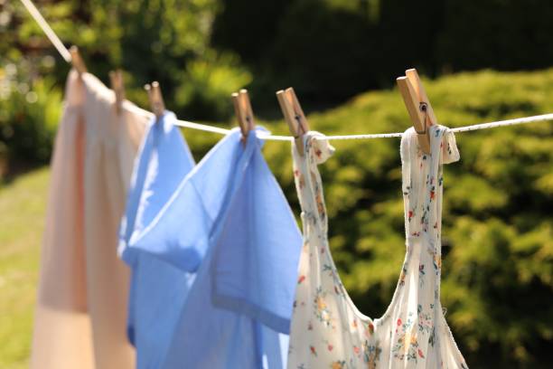 istock Clean clothes hanging on washing line in garden. Drying laundry 1483962505