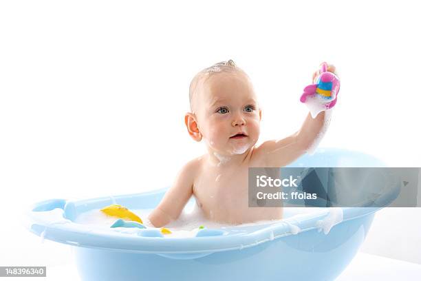 Baby In Blue Bathtub Holding Up A Toy Stock Photo - Download Image Now - Baby - Human Age, Sitting, White Background