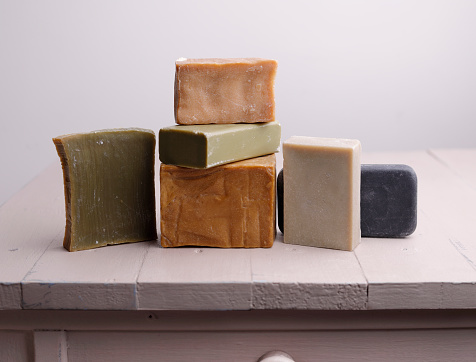 Different natural soap bars on rustic table