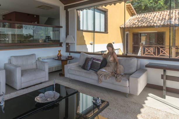 istock Mature woman with coffee cup on a mansion sitting on sofa 1483973799