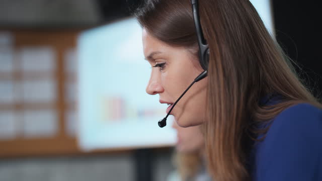 Call center operators answer the phone to assist customers in using the service. Close up of Call center woman wearing headset with microphone talk with customer and answer question in the office.