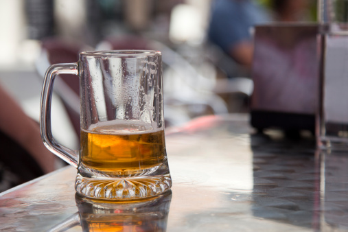 Glass of beer served in the outdoor patio of a Bar.