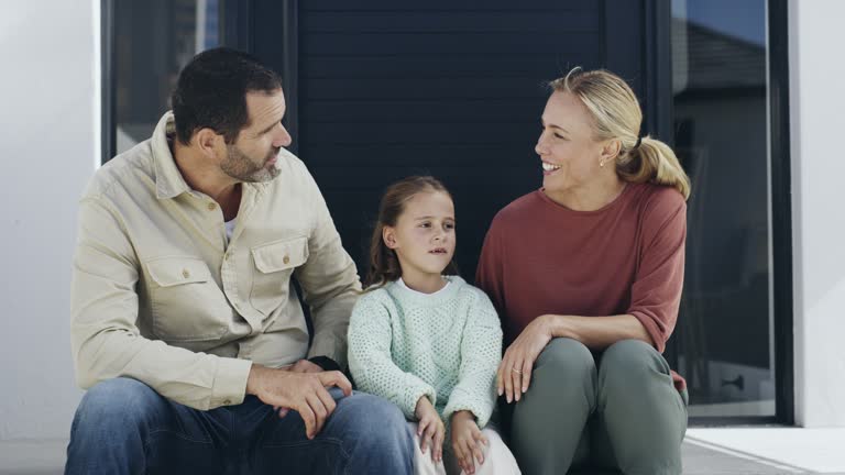 Father, mother and girl in new home talking, relaxing or bonding with support, trust or solidarity together. Parents, dad or mom love enjoying quality time with a young child or kid in family house