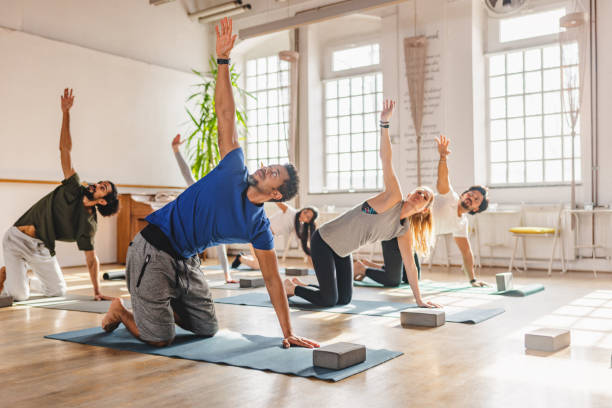 istock Diverse Yoga Practitioners Stretching Their Back As They Are Attending A Group Yoga Class In A Cute Studio 1483989730