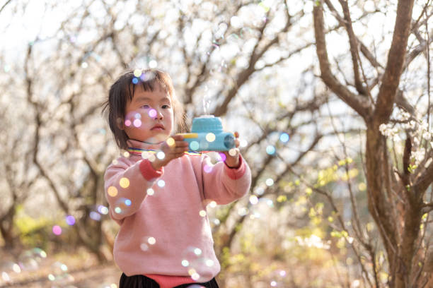 istock A girl blows bubbles with a bubble machine in the plum forest 1483989756