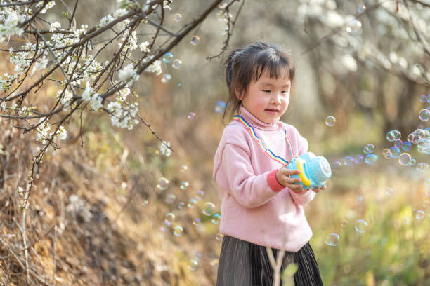 istock A girl blowing bubbles in the plum forest 1483989796