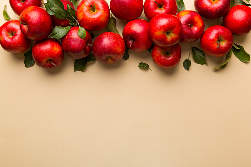 Many red apples on colored background, top view. Autumn pattern with fresh apple above view with copy space for design or text.