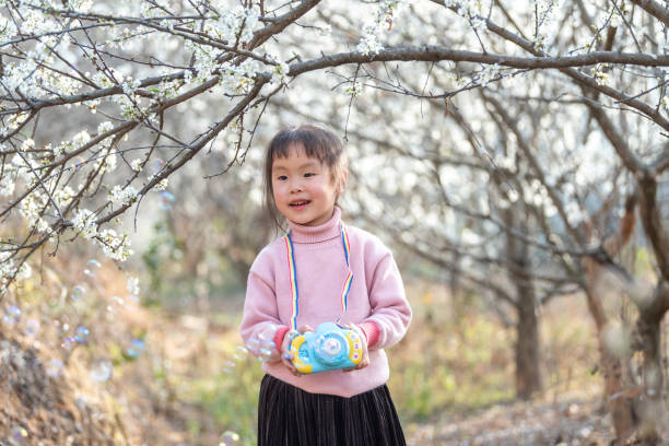 istock A girl blowing bubbles in the plum forest 1483989863