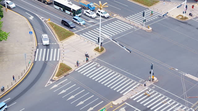 High angle aerial view of traffic flow and pedestrians at urban intersections