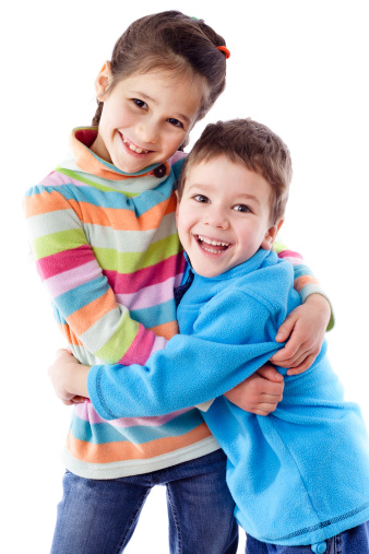 Two happy funny kids standing together and embracing, isolated on white