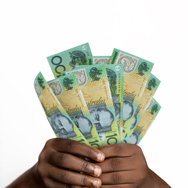 istock hands holding 3D rendered 100 Australian dollar notes. closeup of Hands holding Australian currency notes 1483995130