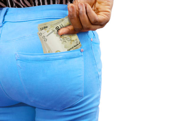istock lady putting few 100 Bahamian dollar notes into her back pocket. Removing money from pocket, hold money 1483998917
