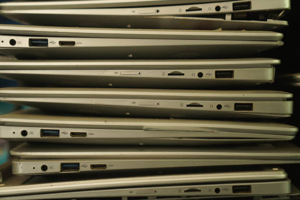 istock Pile of old used laptop computers for recycling on white table. Planned obsolescence, e-waste, electronic waste for reuse and recycle concept 1483999302