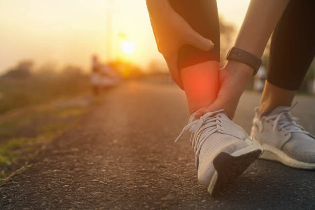 accidente de esguince de tobillo en ejercicio deportivo correr trotando.iluminación discreta. - sport massaging accident adult fotografías e imágenes de stock