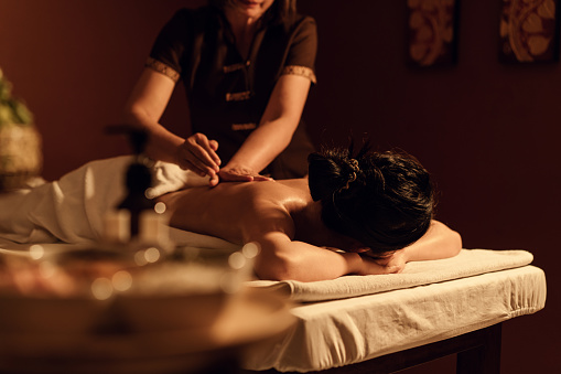 Relaxation woman back massage with masseur in cosmetology spa centre. Relaxing female customer get service aromatherapy massage with masseuse in spa salon. Selective focus.