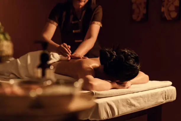 Relaxation woman back massage with masseur in cosmetology spa centre. Relaxing female customer get service aromatherapy massage with masseuse in spa salon. Selective focus.