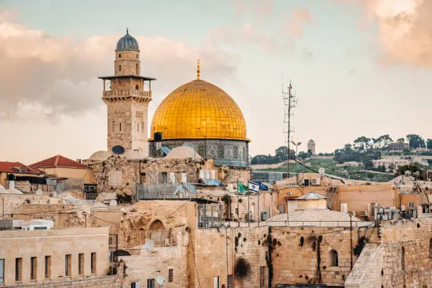 Iconic view towards the golden Dome and Minaret of the famous Al-Aqsa Mosque - Qibli Mosque in the old town of Jerusalem close to the Western Wall in teh Jewish Quarter of Jerusalem under blue summer sky. Jerusalem Old Town, Jewish Quarter, Israel, Middle East.