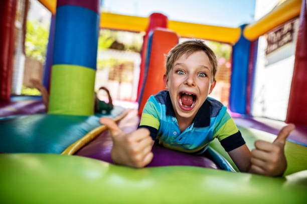 istock Little boy having extreme fun in inflatable bouncy castle playground 1484030232