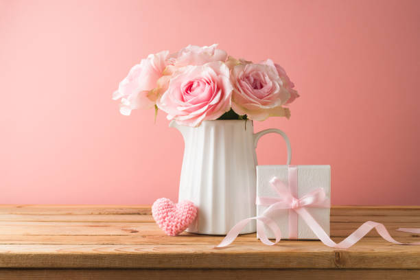 conceito feliz do dia das mães com flores de rosas, forma do coração e caixa de presente na mesa de madeira sobre o fundo rosa - rose mothers day flower pink - fotografias e filmes do acervo