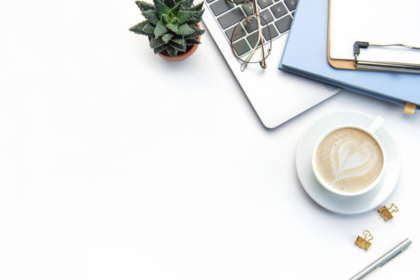istock Modern white office desk table with laptop, notebook and other supplies. 1484033370