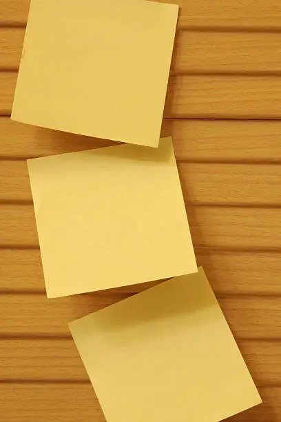 three yellow notes stick on the wood cabinet