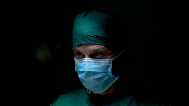 istock Close-up face eyes doctor in operating room has determined look in eyes, ready perform surgery for patients are in operating room doctor wears hat collect hair cloth scraps for cleanliness and safety. 1484038163