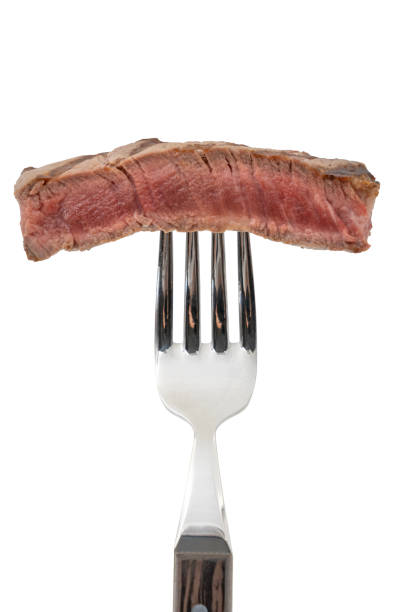 istock Slice of beef steak on meat fork isolated on white background. 1484038465