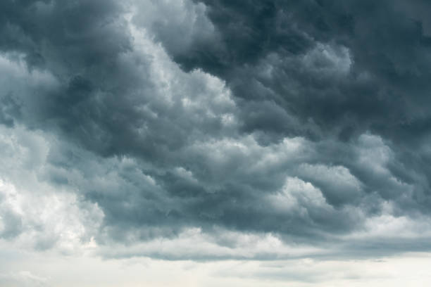 istock storm cloud background during raining. Dark Clouds. Huge black clouds on dark sky before a thunder-storm. 1484038506