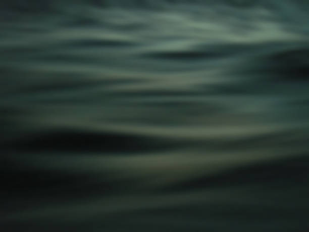 istock Dark black and turquoise colored ocean surface with wave line image texture. 1484044099
