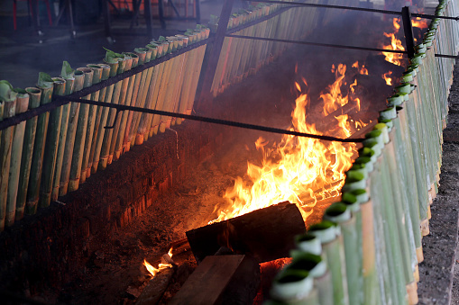 Bamboo sticks with glutinous rice and coconut milk are arranged ear fireplace for lemang (glutinous rice cooked with coconut milk in hollowed bamboo) preparation
