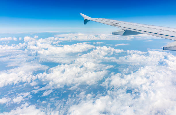 istock View from the airplane window at a beautiful cloudy sky and the airplane wing 1484047521