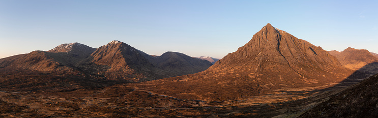 Stob Dearg and Stob a' Ghlais Choire in the Scottish Highlands bathed in the first early morning rays of sunshine on a cloudless spring day.