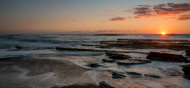 istock Dramatic beautiful sunset on a rocky coast. Bright sun light on the horizon 1484049329
