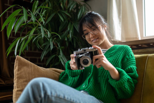 istock Smiling asian young girl with an old-fashioned camera 1484058128