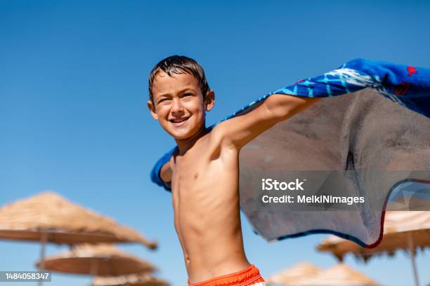 Boy Playing Superhero With Towel On The Beach Stock Photo - Download Image Now - Beach, Boys, Cheerful