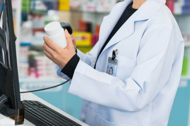 istock Closeup young pharmacist scanning barcode of mockup qualified pill bottle. 1484063717