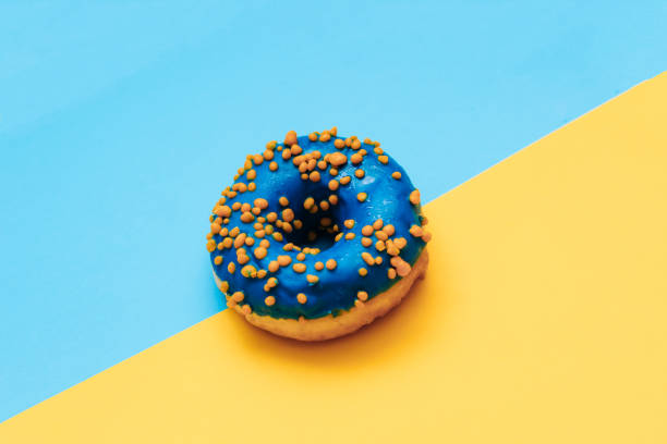 istock Blue-yellow glaze donut on blue-yellow paper 1484070148
