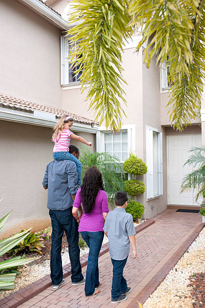 Multi ethnic family walking to front door stock photo