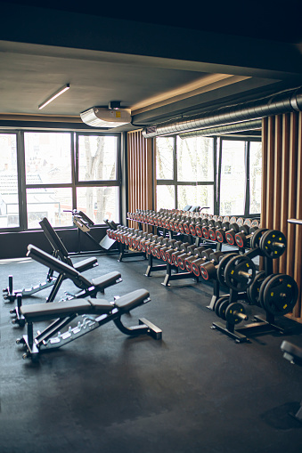 Excercise equipment in a modern gym, benches and weights. No people