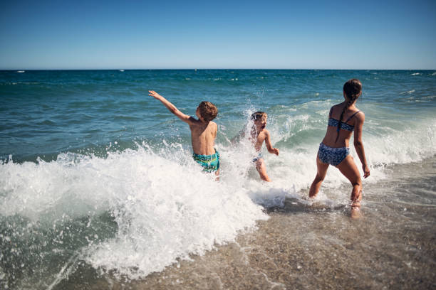 istock Children enjoying huge waves on beach 1484092926